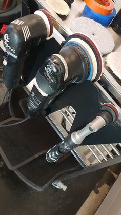 two electric polishers sitting on top of a table next to other tools and accessories