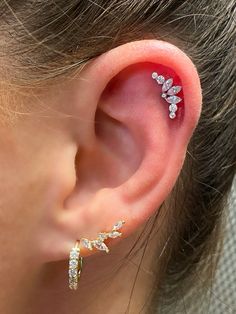 a close up of a person's ear with some piercings on it,