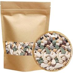 a bag filled with lots of different colored rocks next to a small bowl full of gravel