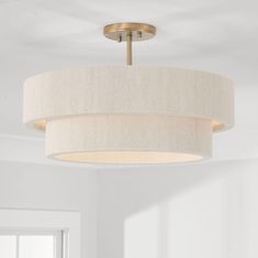 a light fixture hanging from the ceiling in a room with white walls and flooring