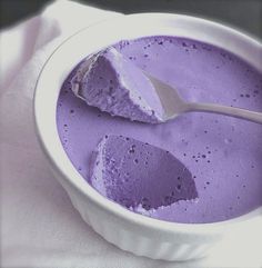 a white bowl filled with purple food and a spoon