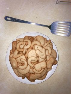 a white plate topped with cut up cookies next to a fork on top of a table