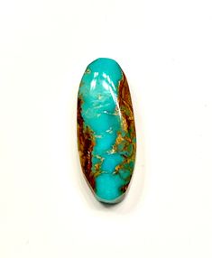 a turquoise and gold colored stone on a white surface