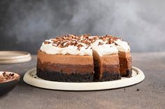 a chocolate cake with white frosting and chopped nuts