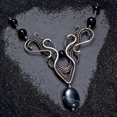 This is a very elegant and feminine necklace which will not go unnoticed. By careful hammering and filing, the ends of the wires have been shaped into three-dimensional swirls while the thinnest wire available was used to weave all the components together. Black onyx beads complete the piece. Made with genuine recyled 925 sterling silver which has been oxidised to bring out the weave. Comes in an organza gift bag with a free jewellery polishing cloth. Perfect for a special occasion or that speci Sarah Thompson, Feminine Necklace, Onyx Bead, Organza Gift Bags, Wire Wrap, Free Jewelry, Black Onyx