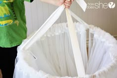 a baby in a crib being held up by a person with a green t - shirt