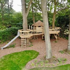 a wooden play structure in the middle of some trees