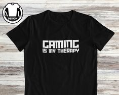 Looking for a shirt for a true gamer, look no further than our collection of gaming shirts, they sure to pleasing and being a hit! **If you want a different print colour to be printed on any of my T-shirts than what is shown in listing, just give me a message that you want a different colour and will gladly see if iI can print the colour that you want**  These t-shirts is very popular, with great qaulity, softness and comfort that you will feel straight away,  Printed with long lasting, quality Black Gaming Tops With Graphic Design, Black Gamer Top With Screen Print, Black Gamer T-shirt With Letter Print, Black Gamer T-shirt With Screen Print, Black Gamer Tops With Logo Print, Black Cotton T-shirt For Gaming Events, Black Gamer Top With Funny Text, Gamer Tops With Letter Print, Black Gamer T-shirt With Funny Text