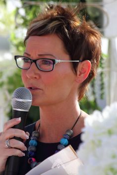 a woman with glasses holding a microphone