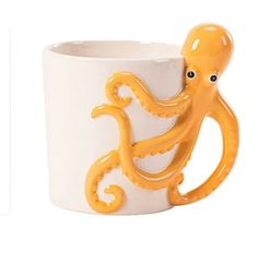 an orange octopus mug is sitting on a white cup with its mouth open and it's head sticking out