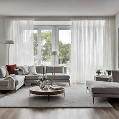 a living room filled with furniture and a large window covered in white drapes