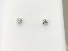 "The diamonds are set in 14 k white gold. The backs and post are also white gold. The diamonds measure 3 millimeters round and the total carat weight is 0.25 carats. The diamonds have a \"J\" color and an \"I 1\" clarity grading. We will provide a earring box." Classic Round Stone Diamond White Earrings, Classic Platinum Diamond Earrings With Single Cut Diamonds, White Diamond Earrings With Prong Setting, Diamond Earrings With Round Stone And Accents, Silver Diamond Earrings With Single Diamond, Classic Diamond Earrings With Single Cut Diamonds, Classic Diamond White Diamond Earrings With Single Cut, Classic White Diamond Earrings With Single Cut Diamonds, Classic White Diamond Earrings With Single Cut