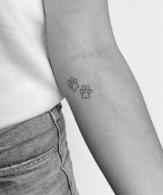 a person with a small paw tattoo on their arm