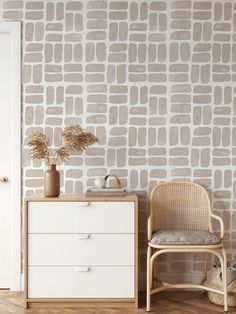 a white dresser sitting next to a wall with a brown brick pattern on it's side