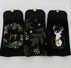 three oven mitts decorated with christmas decorations and deer head on them, sitting next to each other