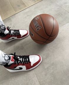 a person standing next to a basketball on top of a cement floor with white socks