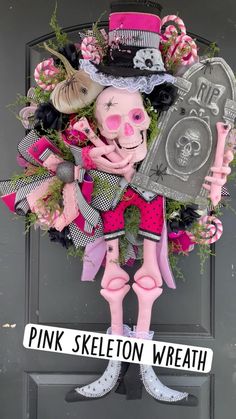 a pink skeleton wreath is hanging on the front door with a sign that says pink skeleton wreath