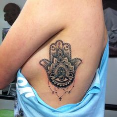 a woman with a hamsa tattoo on her back