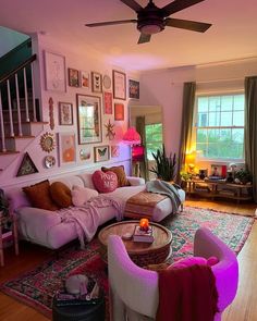 a living room filled with furniture and lots of pictures on the wall next to a window