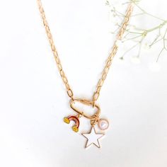 The Rainbow Dream Charm Necklace Is A Trendy New Charm Necklace Featuring A Variety Of Charms. The Charms Include A Large Star, A Smaller Rainbow, And A White Circular Pendant. All Balanced On A Trendy Keychain-Like Design On A Link Chain 20-Inch Chain 3-Inch Extender Star Charm: 1-Inch Width Silver And Gold Plated Brass Dainty White Necklace With Dangling Charms, Trendy White Charm Necklace With Lobster Clasp, White Chain Necklace With Charms, White Dangle Charm Necklaces With Adjustable Chain, Dainty White Chain Necklace With Lobster Clasp, Everyday White Charm Necklace With Adjustable Chain, White Charm Necklace With Adjustable Chain For Everyday, Everyday White Necklace With Lobster Clasp, Bohemian Braided Hair