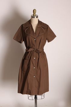 1970's Brown Button Up Short Sleeve Dog Ear Collar Belted Dress by Ship N' Shore  This dress features: *Brown base color *Short sleeved *Button up front *Dog ear collar *Belted *Pocket on front  Label: Ship N' Shore  Size: Large  Measurements: Bust: 39" Waist: 36" Hip: 41" Length: 39 1/2" Condition: Excellent If you have any questions, please ask! Find even more Vintage Medium-Large at: https://www.etsy.com/shop/NaughtyKittyVintage?section_id=17605976&ref=shopsection_leftnav_5 Thanks! -NaughtyKi Brown Cotton Button-up Dress, Vintage Dress With Button Closure For Vintage Fashion, Retro Short Sleeve Dress With Buttons, Retro Vintage Dress With Buttons For Daywear, Retro Vintage Dress With Button Closure, Retro Vintage Dress With Buttons, Vintage Brown Short Sleeve Dress, Brown Vintage Short Sleeve Dress, Retro Brown Short Sleeve Dress