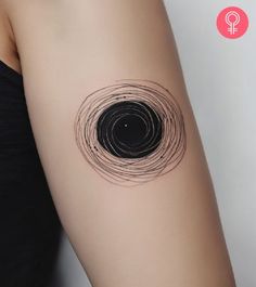 a woman's arm with a black circle tattoo on it