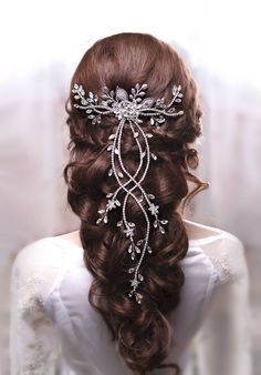 the back of a woman's head wearing a bridal hair comb with pearls and crystals