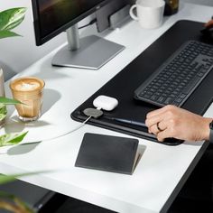 a person sitting at a desk with a keyboard and mouse in front of a computer