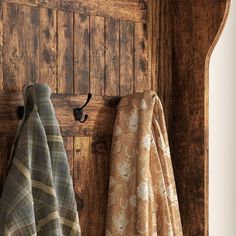 two towels are hanging on a wooden coat rack