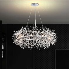 a chandelier hanging from the ceiling in a room with black walls and flooring