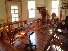 a hammock is in the middle of a room with wooden floors and windows