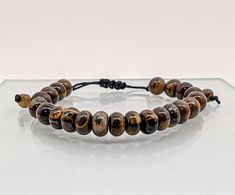 - Material: Tiger Eye - Length: fit for 7 ~ 8 inches wrists - Beads size: About 8 mm - Rondelle Round Beads Any white spots are from camera flash ,they are NOT in the stones. **The appearance of natural stones can vary due to their unique characteristics and natural variations in color, size, and pattern. Eye Bead Bracelet, Bracelet Stone, Unique Characteristics, Tiger Eye Beads, Bracelet Gemstone, Gemstone Beaded Bracelets, Camera Flash, Minimalist Bracelet, Crystal Bracelet