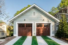 a white house with brown garage doors and green grass