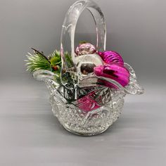 a glass basket filled with lots of different types of flowers