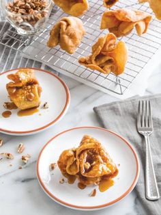 two plates with desserts on them next to a cooling rack full of pastries