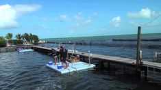 two people standing on a floating platform in the water