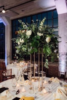 a tall vase filled with white flowers on top of a table