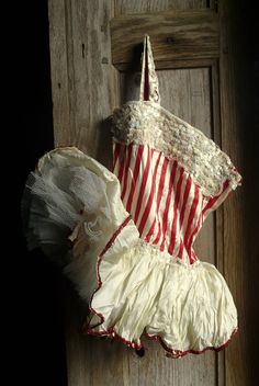 an old fashioned dress hanging on a door