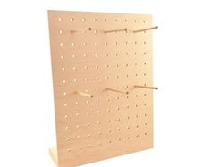 a wooden peg board with holes on it