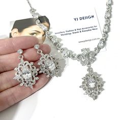 "A glamourous semi parure Victorian wedding vintage style bridal jewelry set with cz dangle earrings and statement necklace featuring intricately detailed Fleur de Lis Damask royalty inspired motifs. They are made of high quality clear cubic zirconia with earrings on sterling silver posts, all framed in white gold silver rhodium tarnish-resistant finish. Earrings are 1 3/8\" (3.5cm) including cz-studded sterling silver posts. Necklace length is adjustable at min 16.5\" (42cm) and max 18.5\" (47c Classic Wedding Jewelry Sets With Sparkling Stones, Glamorous Elegant Jewelry Sets For Wedding, Glamorous Hand Set Bridal Earrings For Wedding, Elegant Bridal Sets With Intricate Design For Party, Classic Crystal Bridal Necklace For Wedding, Glamorous Wedding Jewelry With Intricate Design, Classic Wedding Jewelry Sets With Matching Earrings, Classic Wedding Necklace With Matching Earrings, Wedding Bridal Necklace With Matching Earrings In Cubic Zirconia