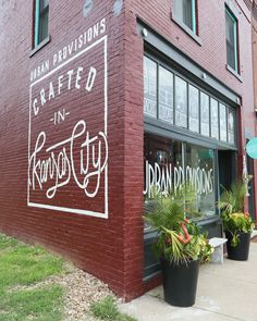 a red brick building with plants in the window