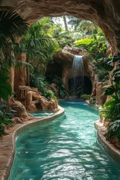 an outdoor swimming pool surrounded by greenery and rocks with a waterfall in the middle