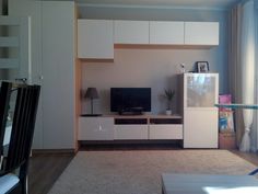 a living room filled with furniture and a flat screen tv on top of a entertainment center