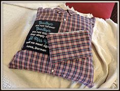 a plaid shirt with a message on the front and back, sitting on a white blanket