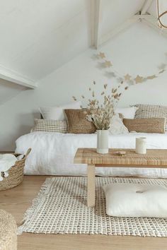 a bedroom with white walls and wooden flooring is decorated in natural materials such as wicker