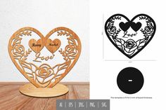 a wooden heart with two hearts cut out of it on top of a wood table