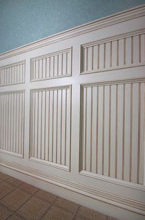 an empty room with white paneling and blue walls