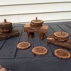 several pieces of wood sitting on top of a table next to small stools and logs