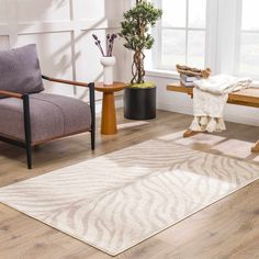 a living room filled with furniture and a white rug