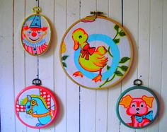 three colorful embroidered wall hangings with animals and birds on them against a white wood background